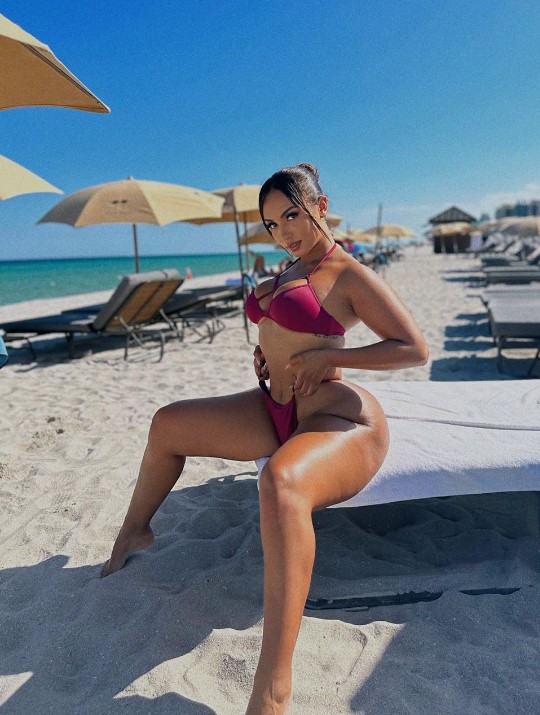 Camila Bernal onlyfans model sitting on the beach wearing pink bikini