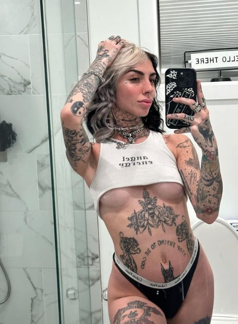 Cruella Morgan onlyfans model ig leaks picture standing wearing a white top