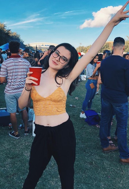 @trihunna onlyfans model wearing a mustard top and holding a red cup