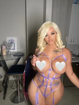 Tyler Wisby onlyfans model picture standing wearing blonde wig and showing her boobs