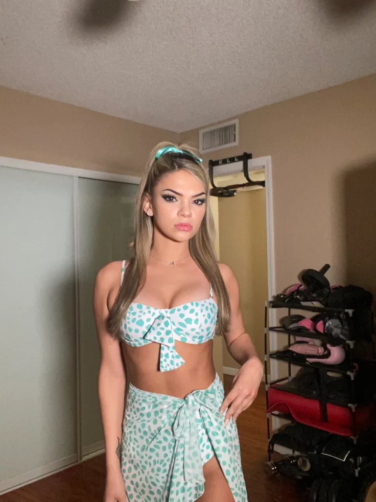 Athena Faris onlyfans model and look alike of Hailee Steinfeld picture standing wearing a green clothes