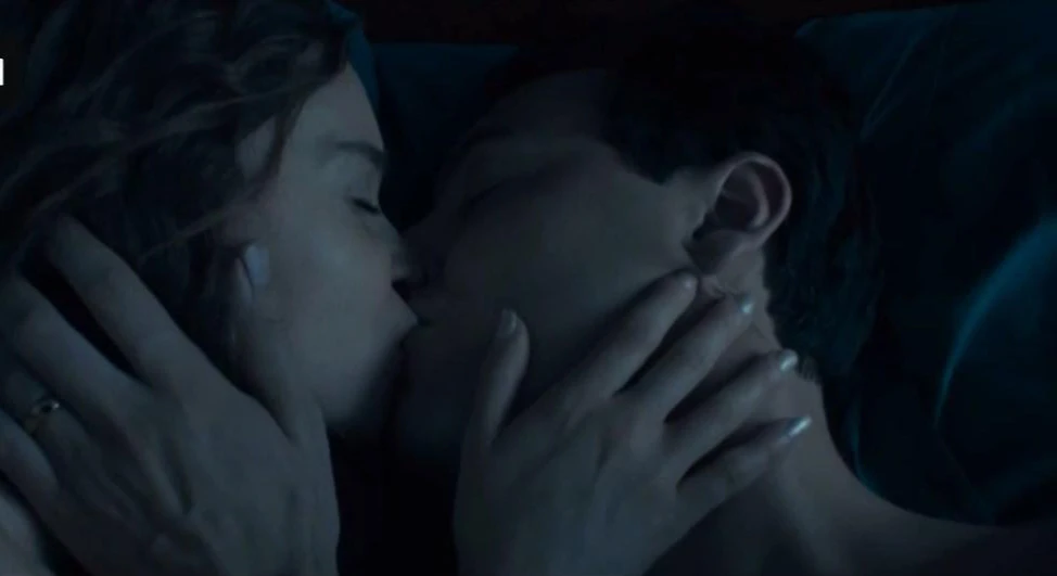 Emilia Clarke leaks in the movie Above Suspicion. She is with a man and they’re kissing