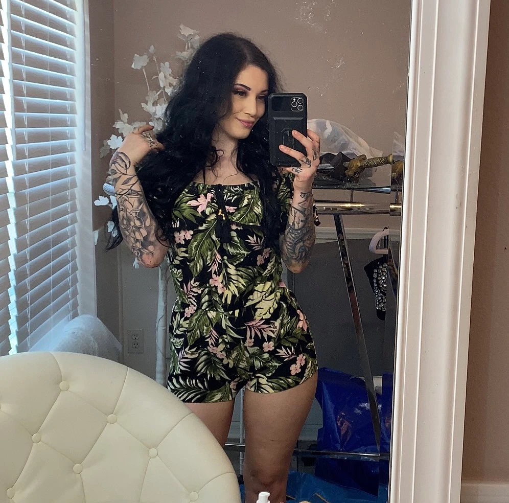 Noelle Easton onlyfans model and look alike of Kat Dennings picture standing wearing floral clothes