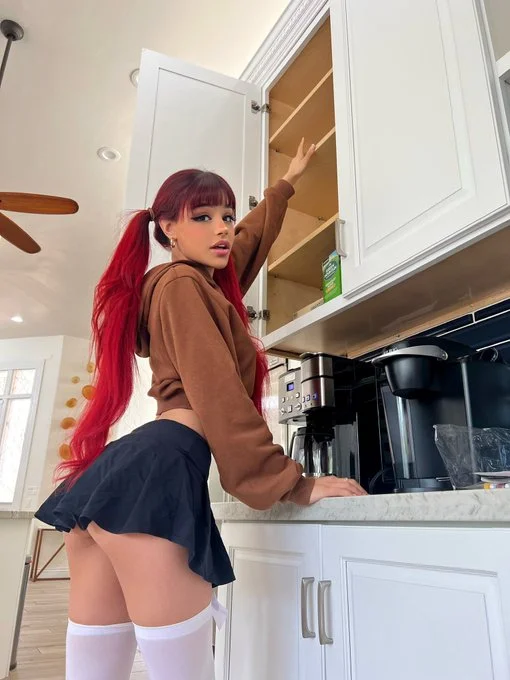 Hannah Jon (@whoahannahjo) OnlyFans model picture in kitchen wearing brown top and black skirt