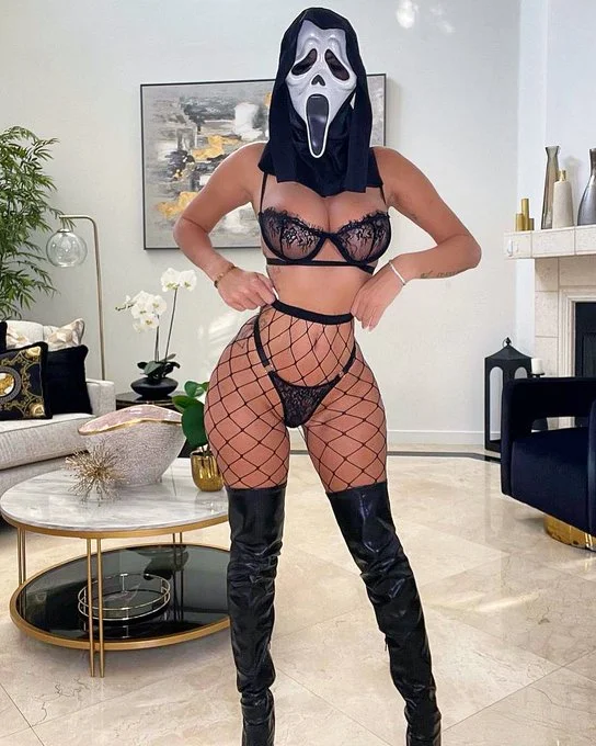 Jessika Gotti (@jessikagotti) OnlyFans model picture standing wearing scary mask and she is wearing black sexy lingerie