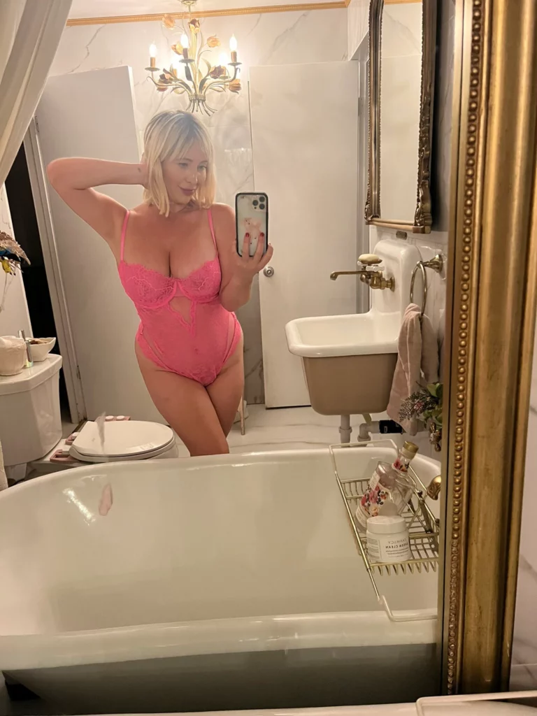 Tasha Reign (@tashareign) OnlyFans model picture in bathroom wearing pink one piece lingerie