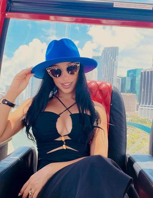 Abella Anderson (@abella_anderson) OnlyFans model picture sitting wearing blue hat and black sexy dress